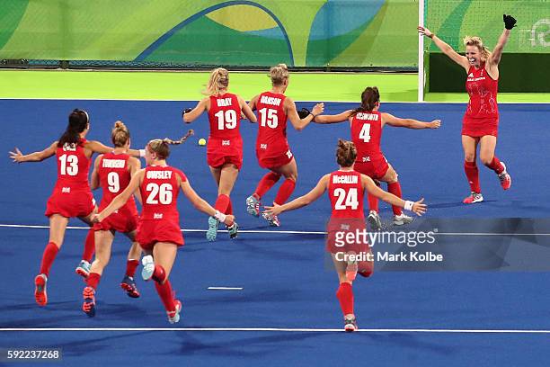 Hollie Webb of Great Britain celebrates with teammates after scoring the game-winning penalty goal against the Netherlands during the Women's Gold...