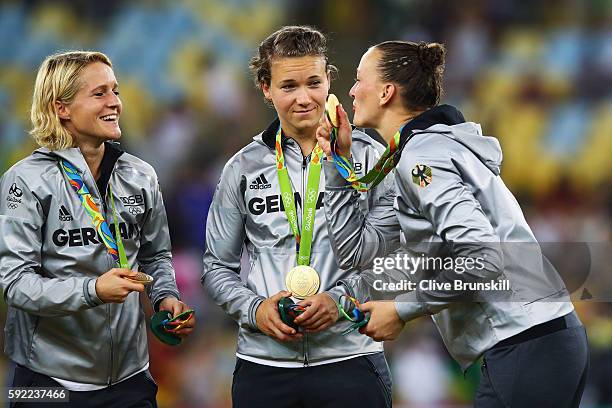 German team captain Saskia Bartusiak celebrates with her players against as they receive their medals following victory in the Women's Olympic Gold...