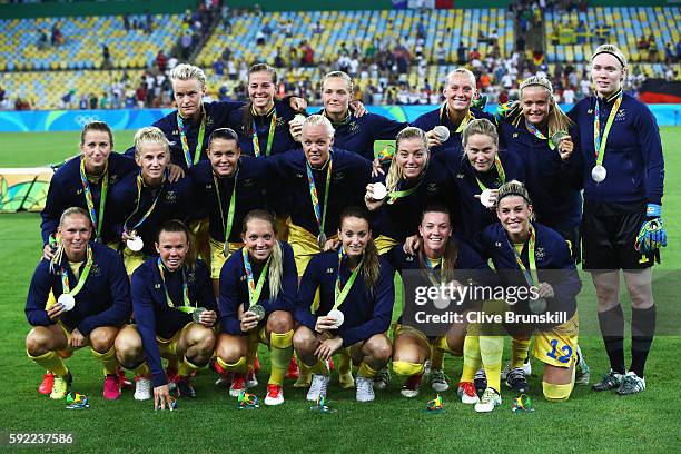 Sweden pose with their silver medals following defeat during the Women's Olympic Gold Medal match between Sweden and Germany at Maracana Stadium on...