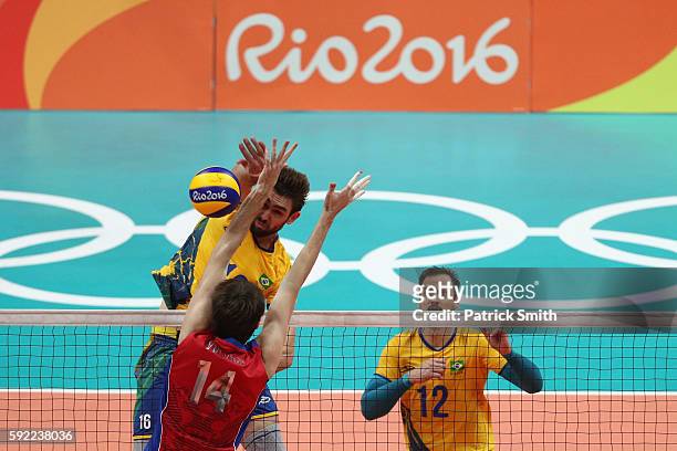 Lucas Saatkamp of Brazil spikes at the Russia defence during the Men's Volleyball Semifinal match on Day 14 of the Rio 2016 Olympic Games at the...