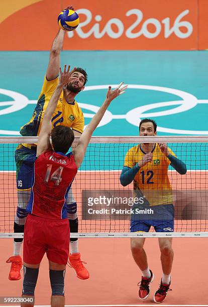 Lucas Saatkamp of Brazil spikes at the Russia defence during the Men's Volleyball Semifinal match on Day 14 of the Rio 2016 Olympic Games at the...