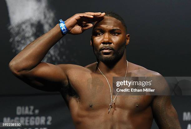 Mixed martial artist Anthony Johnson salutes as he poses on the scale during his weigh-in for UFC 202 at MGM Grand Conference Center on August 19,...