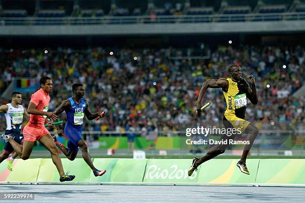 Usain Bolt of Jamaica competes on his way to winning ahead of Aska Cambridge of Japan and Trayvon Bromell of the United States in the Men's 4 x 100m...