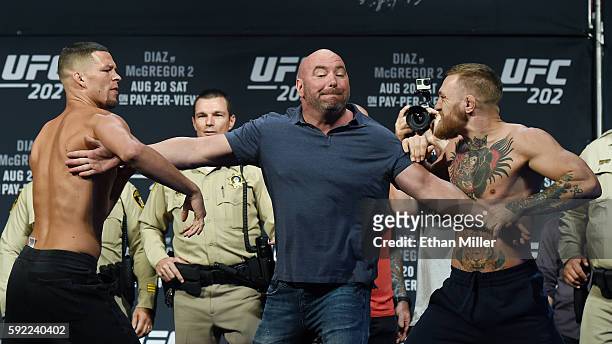 President Dana White separates mixed martial artist Nate Diaz and UFC featherweight champion Conor McGregor as they face off during their weigh-in...