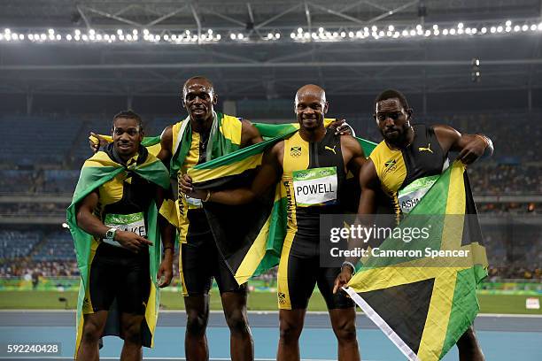 Usain Bolt of Jamaica celebrates with teammates Asafa Powell, Yohan Blake and Nickel Ashmeade after winning the Men's 4 x 100m Relay Final on Day 14...