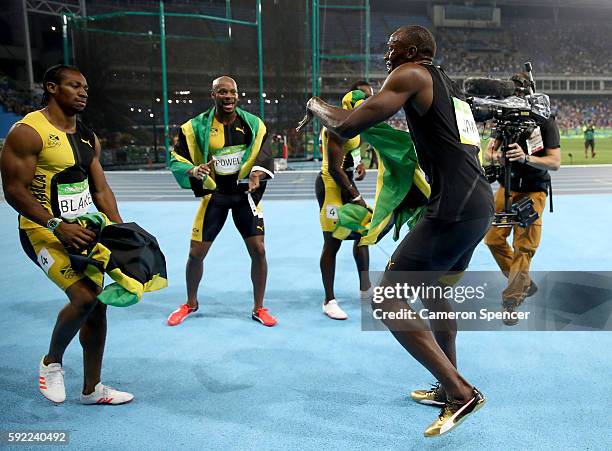 Usain Bolt of Jamaica celebrates with teammates Asafa Powell, Yohan Blake and Nickel Ashmeade after winning the Men's 4 x 100m Relay Final on Day 14...