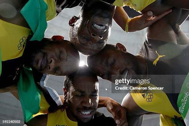 Usain Bolt of Jamaica celebrates with teammates Asafa Powell, Yohan Blake and Nickel Ashmeade after winning the Men's 4 x 100m Relay Final on Day 14...