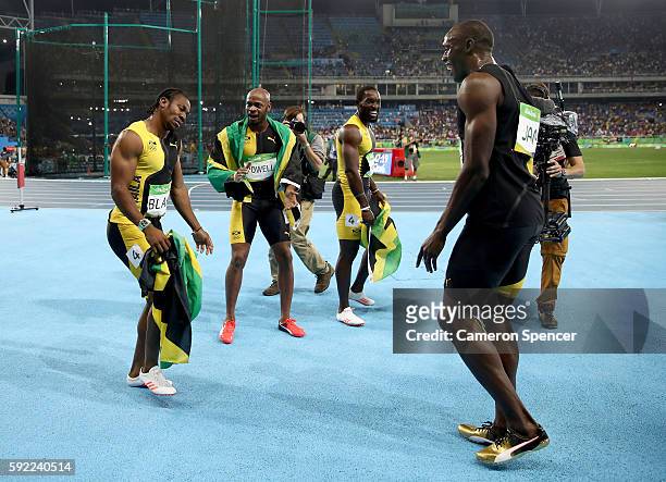 Usain Bolt of Jamaica celebrates with teammates Asafa Powell, Yohan Blake and Nickel Ashmeade after winning the Men's 4 x 100m Relay Final on Day 14...