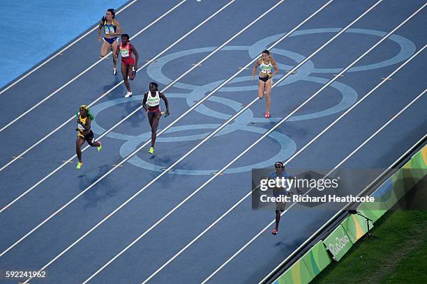 Tori Bowie of the United States, Shelly-Ann Fraser-Pryce of Jamaica and Daryll Neita of Great Britain compete in the Women's 4 x 100m Relay Final on...