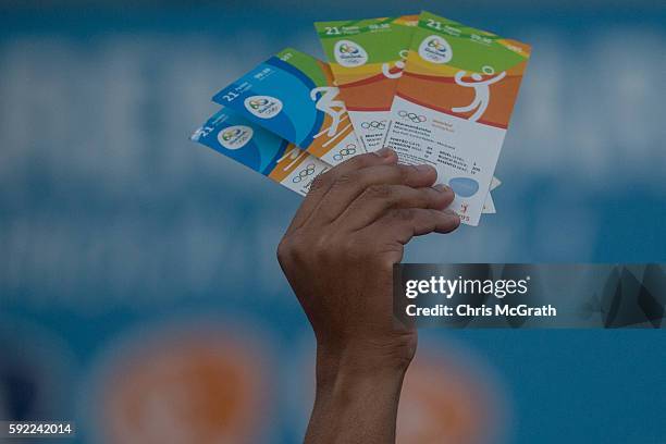 Man holds up tickets to sell or swap outside a venue inside Olympic Park on Day 15 of the Rio 2016 Olympic Games on August 19, 2016 in Rio de...