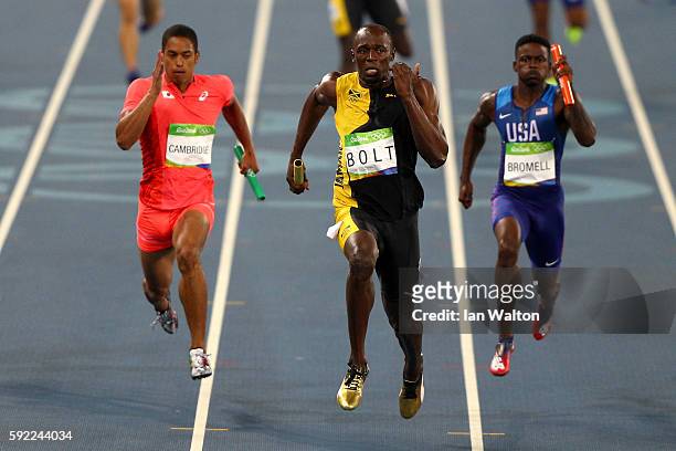 Usain Bolt of Jamaica crosses the finishline to win ahead of Aska Cambridge of Japan and Trayvon Bromell of the United States in the Men's 4 x 100m...