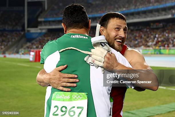 Silver medalist Ivan Tsikhan of Belarus and gold medalist Dilshod Nazarov of Tajikista embrace after the Men's Hammer final on Day 14 of the Rio 2016...