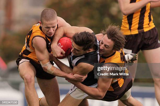 Nick Gray of Collingwood Magpies gets tackled by Zac Webster and Sam Switkowski of Box Hill Hawks during the round 20 VFL match between the Box Hill...