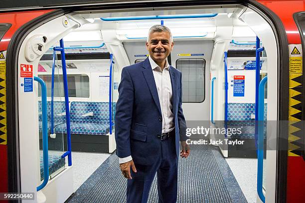 London Mayor Sadiq Khan poses in front of the open doors of a train car during the first Night Tube train to leave from Brixton Underground Station...