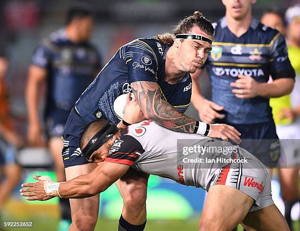 Ethan Lowe of the Cowboys is tackled by Thomas Leuluai of the Warriors during the round 24 NRL match between the North Queensland Cowboys and the New...