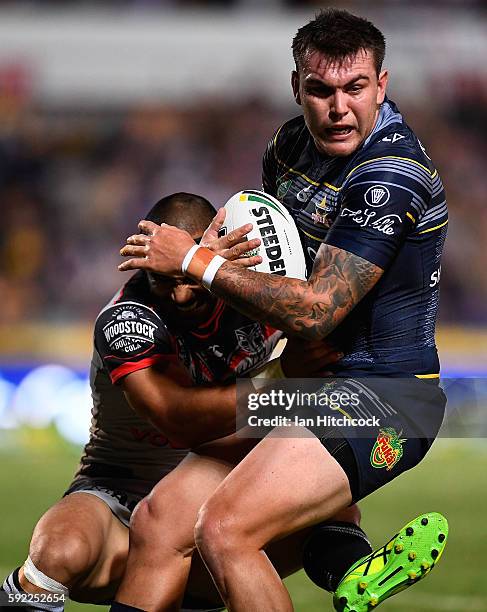 Kyle Feldt of the Cowboys is tackled by Thomas Leuluai of the Warriors during the round 24 NRL match between the North Queensland Cowboys and the New...