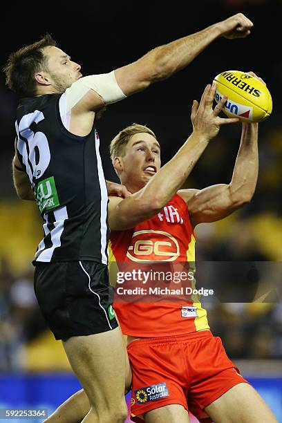 Tom Lynch of the Suns marks the ball against Nathan Brown of the Magpies during the round 22 AFL match between the Collingwood Magpies and the Gold...