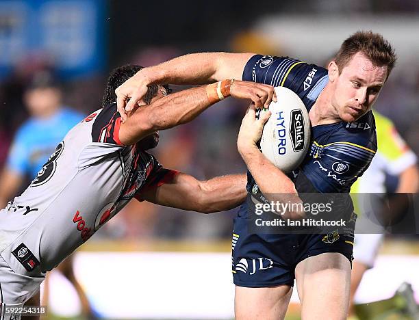 Michael Morgan of the Cowboys is tackled by Matthew Allwood of the Warriors during the round 24 NRL match between the North Queensland Cowboys and...