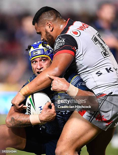 Johnathan Thurston of the Cowboys is tackled by Sam Lisone of the Warriors during the round 24 NRL match between the North Queensland Cowboys and the...