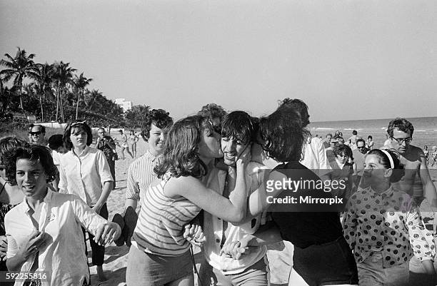 Ringo Starr is besieged by schoolgirls as he strolls on a beach in Miami, Florida, as the group enjoy a short break during their Winter 1964 US Tour,...