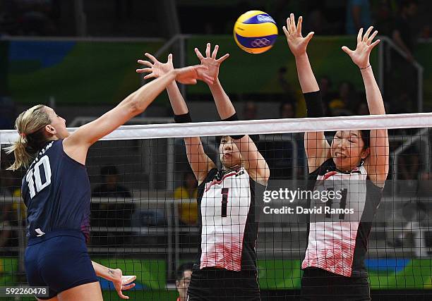 Jordan Larson-Burbach of The United States spikes the ball past Miyu Nagaoka and Erika Araki of Japan during the Women's Quarterfinal match between...