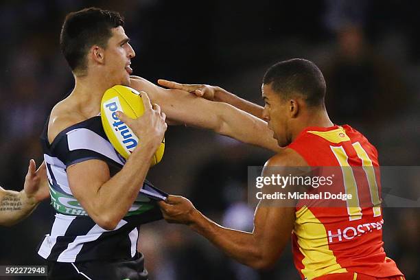 Scott Pendlebury of the Magpies is tackled by Touk Miller of the Suns during the round 22 AFL match between the Collingwood Magpies and the Gold...