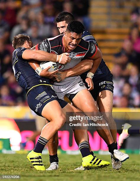 Albert Vete of the Warriors is tackled by James Tamou and Scott Bolton of the Cowboys during the round 24 NRL match between the North Queensland...