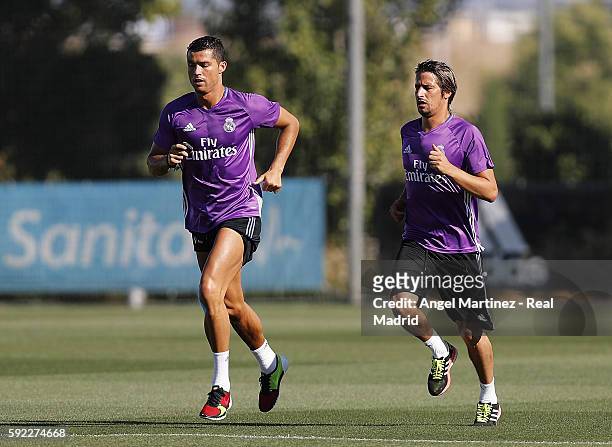 Cristiano Ronaldo and Fabio Coentrao of Real Madrid warm up during a training session at Valdebebas training ground on August 20, 2016 in Madrid,...