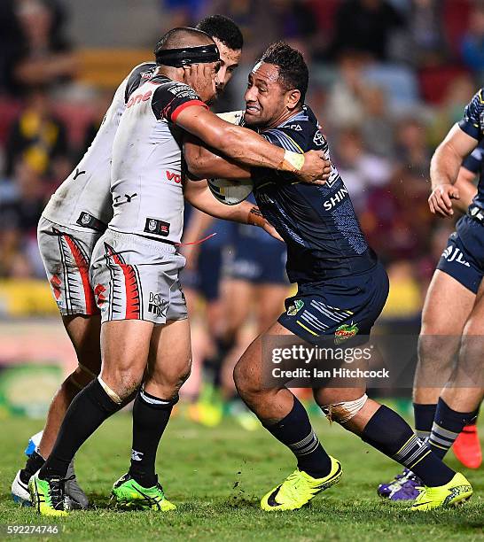 Patrick Kaufusi of the Cowboys is tackled by Thomas Leuluai of the Warriors during the round 24 NRL match between the North Queensland Cowboys and...