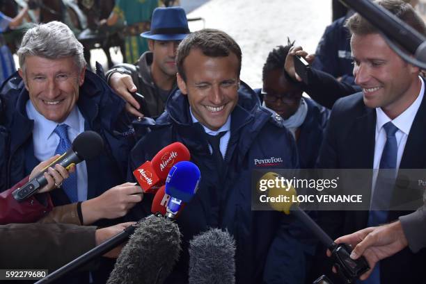 French Economy Minister Emmanuel Macron flanked by French "Mouvement pour la France" president, and creator of the Puy-du-Fou theme park Philippe De...
