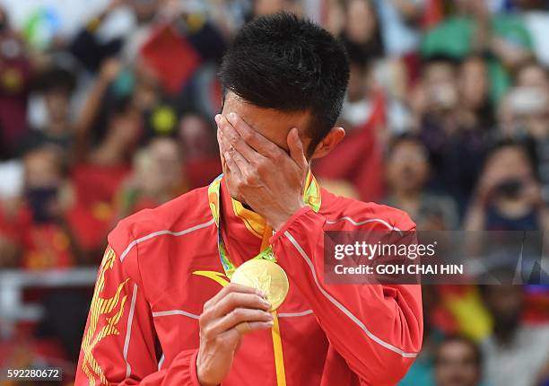 Gold medalist China's Chen Long stands with his medal following the men's singles Gold Medal badminton match at the Riocentro stadium in Rio de...
