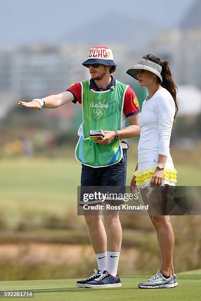 Maria Verchenova of Russia and her caddie line up a putt on the seventh green during the Women's Golf Final on Day 15 of the Rio 2016 Olympic Games...