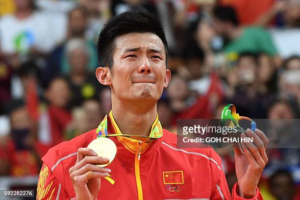 Gold medalist China's Chen Long reacts as he stands with his medal following the men's singles Gold Medal badminton match at the Riocentro stadium in...