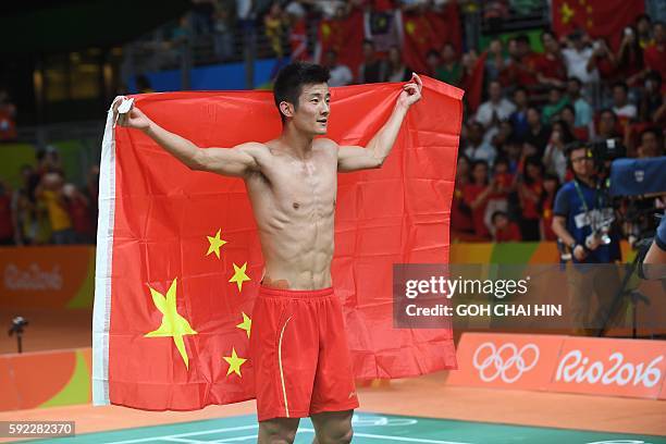 China's Chen Long holds the Chinese flag as he celebrates after winning against Malaysia's Lee Chong Wei during their men's singles Gold Medal...
