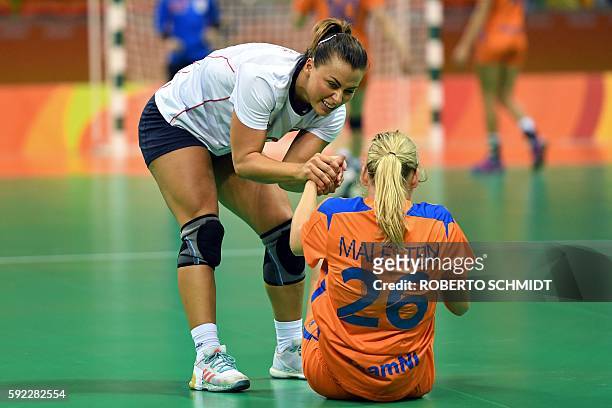 Norway's right back Nora Mork helps Netherlands' right wing Angela Malestein to satnds up after a fall during the women's Bronze Medal handball match...