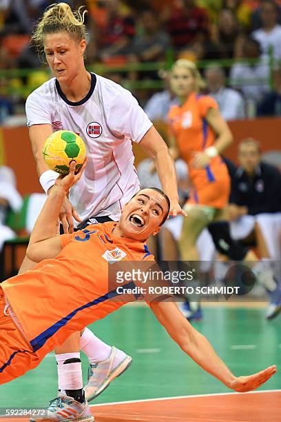 Netherlands' pivot Yvette Broch falls as she shoots past Norway's pivot Marit Malm Frajford during the women's Bronze Medal handball match...