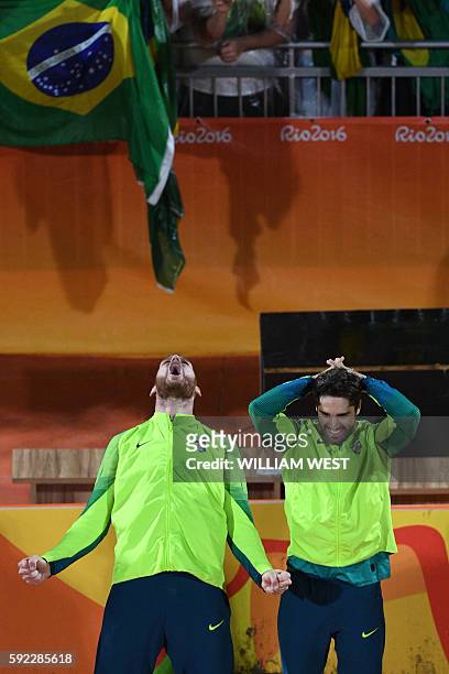 Brazil's gold medallists Alison Cerutti and Bruno Oscar Schmidt celebrate on the podium at the end of the men's beach volleyball event at the Beach...