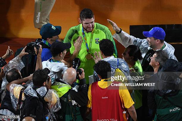 Brazil's gold medallists Alison Cerutti is congratulated on the podium at the end of the men's beach volleyball event at the Beach Volley Arena in...