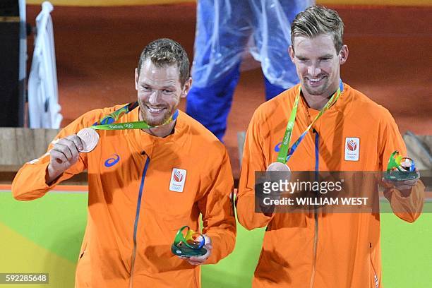 Netherlands' bronze medallists Alexander Brouwer and Robert Meeuwsen celebrate on the podium at the end of the men's beach volleyball event at the...