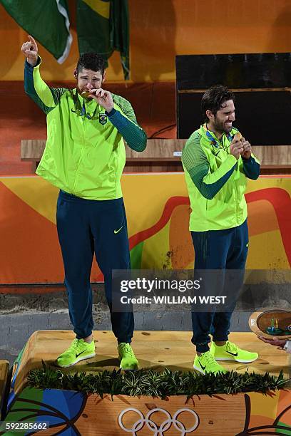 Brazil's gold medallists Alison Cerutti and Bruno Oscar Schmidt celebrate on the podium at the end of the men's beach volleyball event at the Beach...