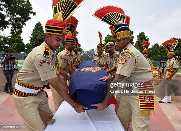 Delhi Police soldiers carry a flag-draped coffin containing the body of martyr Constable Anand Singh, who was shot dead by unknown assailants after...