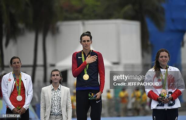 S Gwen Jorgensen sings her national anthem after getting the gold medal, next to Switzerland's Nicola Spirig with the silver and Britain's Vicky...