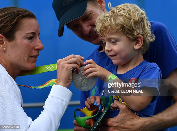 Switzerland's Nicola Spirig shows her silver medal to her family after the women's triathlon at Fort Copacabana during the Rio 2016 Olympic Games in...
