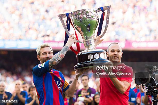 Lionel Messi and Andres Iniesta of FC Barcelona lift up the Spanish La Liga 2015-2016 season trophy before the La Liga match between FC Barcelona and...