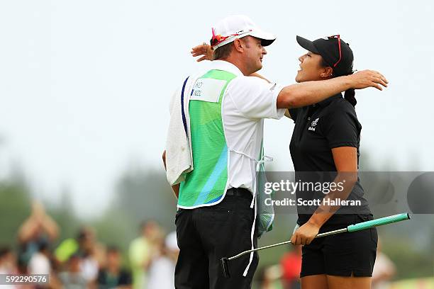 Lydia Ko of New Zealand celebrates with her caddie after putting for birdie on the 18th green to win silver during the Women's Golf Final on Day 15...