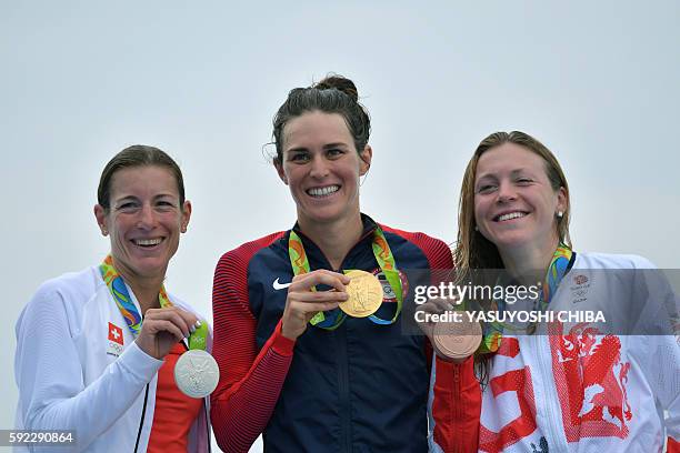 S Gwen Jorgensen celebrates with her gold medal next to Switzerland's Nicola Spirig with the silver and Britain's Vicky Holland with bronze on the...