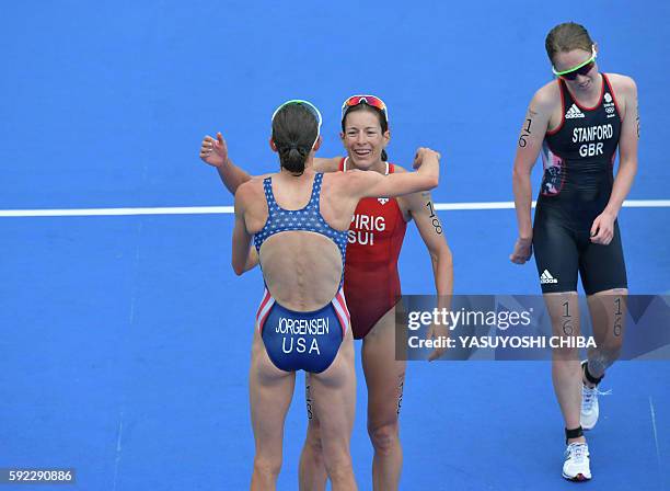 Gold medal winner USA's Gwen Jorgensen hugs second place Switzerland's Nicola Spirig as fourth place Britain's Non Stanford crosses the finish line...