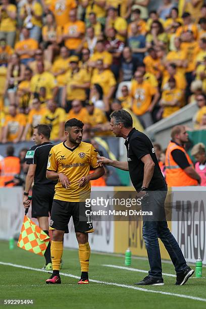 Head coach of Dresden Uwe Neuhaus speaks with Aias Aosman during the DFB Cup match between Dynamo Dresden and RB Leipzig at DDV-Stadion on August 20,...