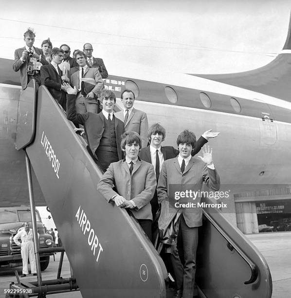 Northern premiere of The Beatles film A Hard Day's Night in Liverpool. The band make their way down the steps of the plane after arriving at...