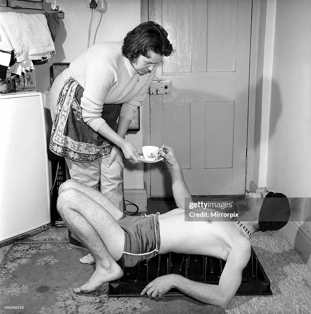 Frank Pepper, Fakir seen here laying on a bed of nails whilst enjoying a cup of tea. January 1964 A994-002